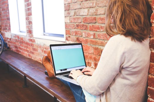 Woman using computer on a bench